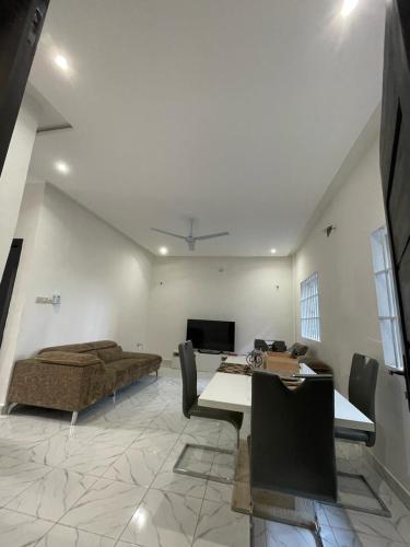 ein Wohnzimmer mit einem Bett und einem Tisch darin in der Unterkunft Fassinou in Cotonou