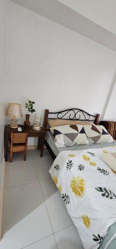 a bedroom with a bed and a table with a lamp at Homey822 in Davao City