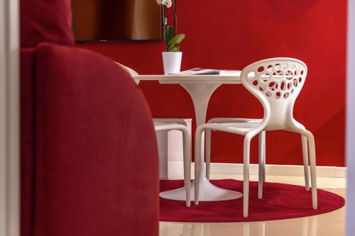 a white table and two white chairs in a room at Opera Relais De Charme - Aparthotel in Verona