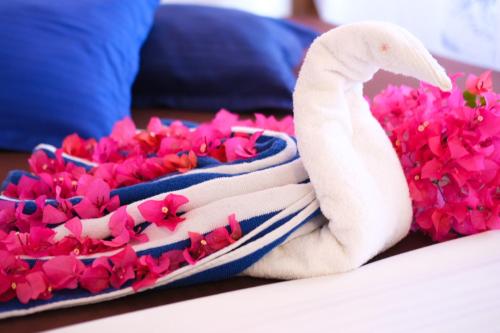 a towel with a seahorse next to pink flowers at Ceylon's House in Hikkaduwa