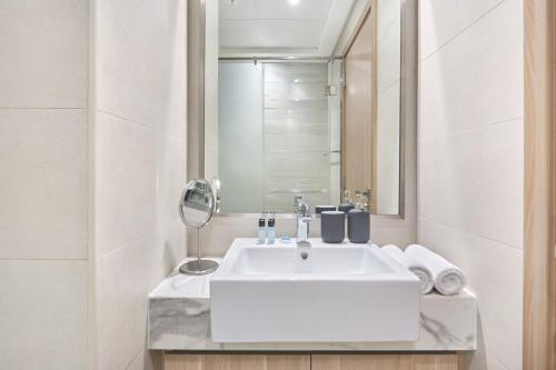 a bathroom with a white sink and a mirror at Elegant Cozy Stu Luxury Stay 10 Min Dubai Mall in Dubai