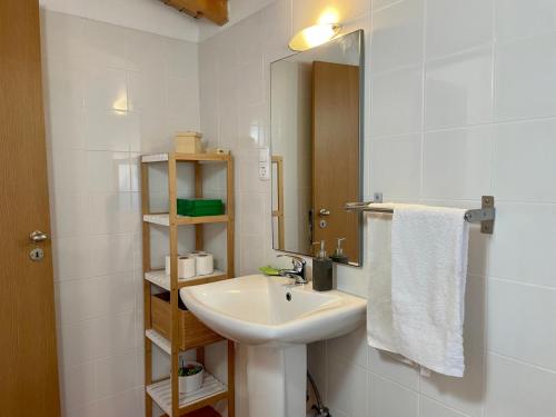 a white bathroom with a sink and a mirror at Casas do Montinho in Melides