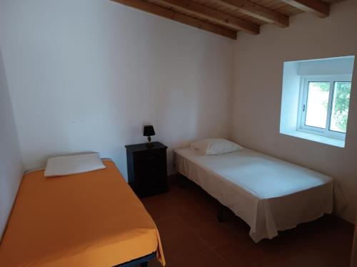 a bedroom with two beds and a window at Casas do Montinho in Melides