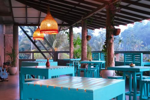 a restaurant with blue tables and chairs and lights at Ceylon's House in Hikkaduwa