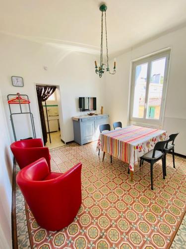 un salon avec des chaises rouges et une table dans l'établissement Clair Matin - Appartement Balcon - Maison privée, à Lamalou-les-Bains