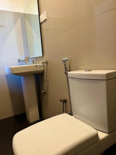 a bathroom with a white toilet and a sink at Kamatha Hotel & Restaurant in Ambalantota