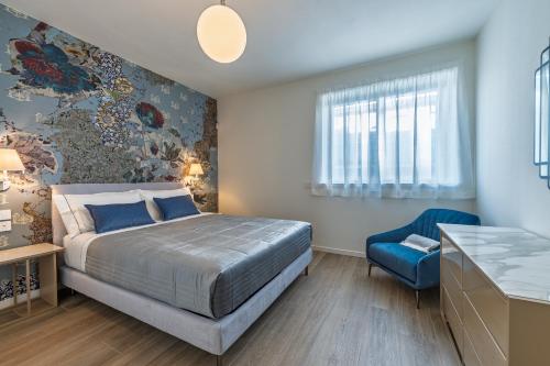 a bedroom with a bed and a blue chair at Treviglio a 20 da Milano Trilocale MONNALISA in Treviglio