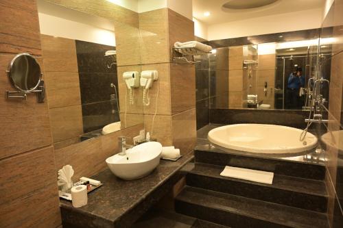 a bathroom with a sink and a tub at HK Clarks Inn, Amritsar in Amritsar