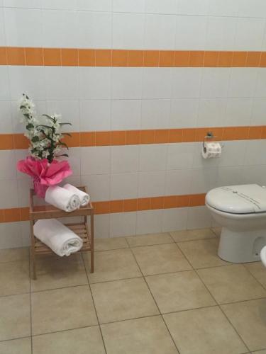 a bathroom with a toilet and a table with towels at Appartamenti Leonardo in Rho