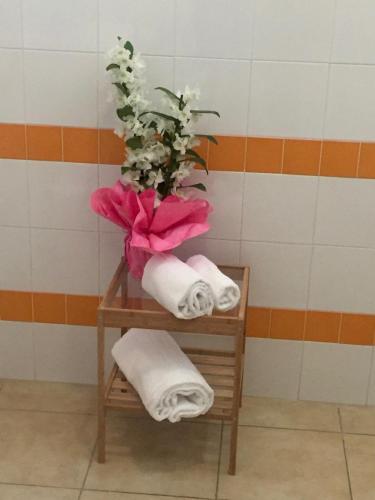 a towel rack with towels and a vase of flowers at Appartamenti Leonardo in Rho