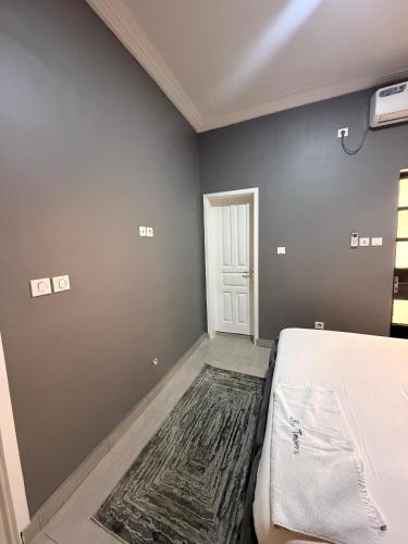 una camera da letto con un letto e un tappeto sul pavimento di The towers shortlets a Douala