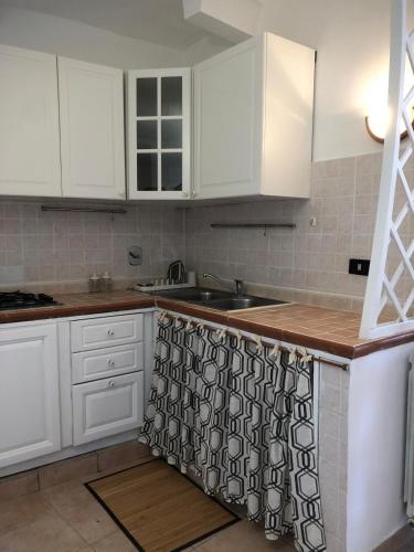 a kitchen with white cabinets and a sink at La Dimora Etrusca in Nepi