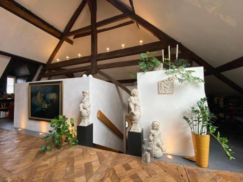a room with statues and plants on the floor at The Castle Loft - Pascal's Angels in Clemency