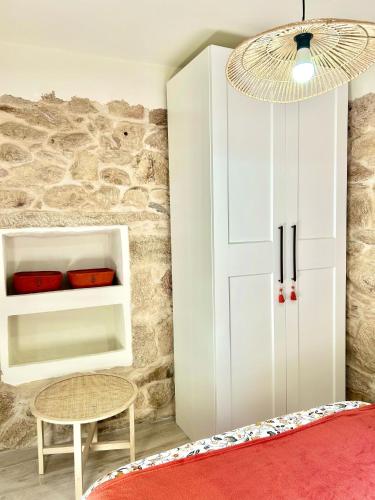 a bedroom with a white cabinet and a table at O lar do magnolio in Pontevedra