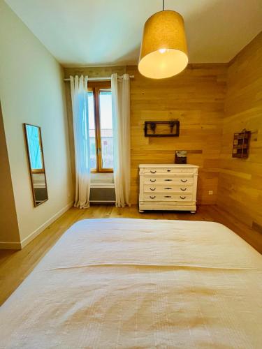 a bedroom with a large bed and a dresser at Maison Stony - Gîtes & Vignoble in Frontignan