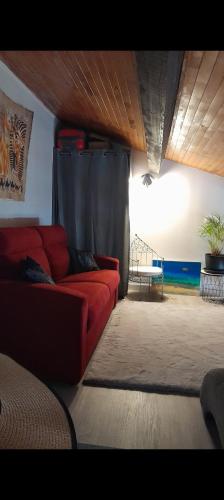 - un salon avec un canapé rouge et une fenêtre dans l'établissement Maison village occitan accès direct à la plage, au Cap d'Agde