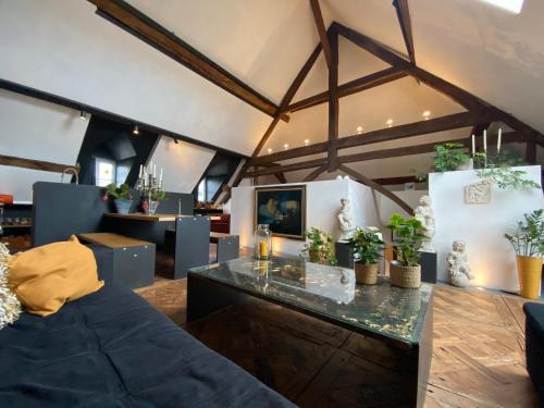 a living room with a glass table and potted plants at The Castle Loft - Pascal's Angels in Clemency