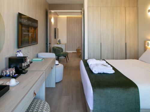 a hotel room with a bed and a bathroom at Mercure Larnaca Finikoudes Beach in Larnaka