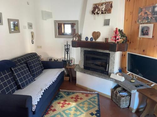 a living room with a blue couch and a fireplace at Bormio and Livigno house in Isolaccia