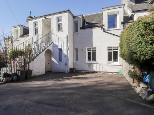 a white house with a staircase and a driveway at Faodail Glenlia in Foyers
