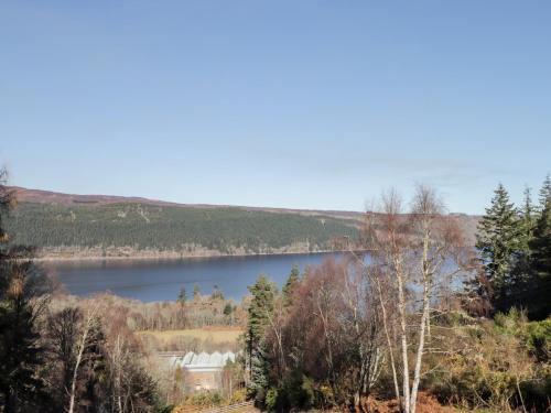 a view of a lake with a house and trees at Faodail Glenlia in Foyers