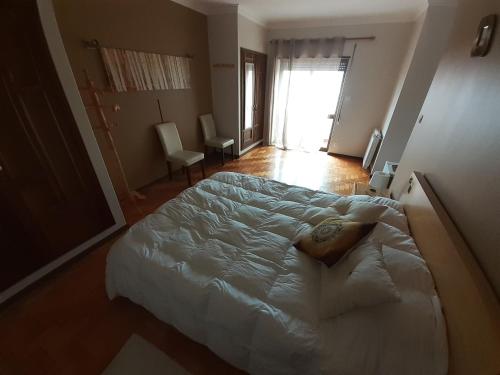 a bedroom with a large white bed in a room at Morada do Ultramar in Viana do Castelo