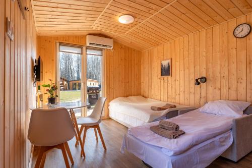 - une chambre avec 2 lits, un bureau et une table dans l'établissement Zacisze obok Suntago Park noclegi 2 3 6 osobowe domki, à Grabce