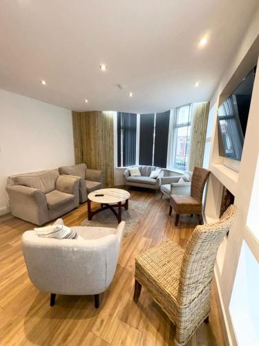 a large living room with a couch and chairs at Beach House By Sasco in Blackpool