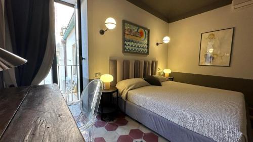 Un dormitorio con una cama y una mesa y una ventana. en Montalto Luxury House, en Siracusa