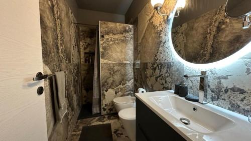 Un baño con lavabo, espejo e inodoro. en Montalto Luxury House, en Siracusa