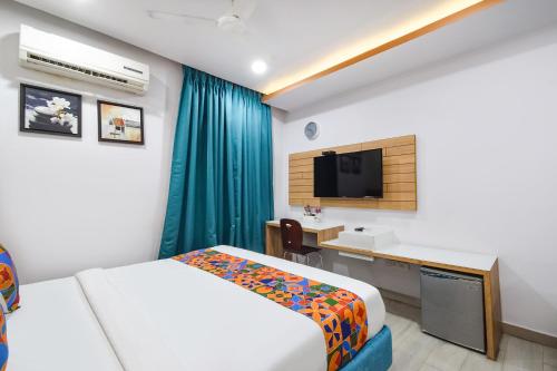 a hotel room with a bed and a desk and a tv at Oriva Aditya Homes Nr ISB, Gachibowli in Hyderabad