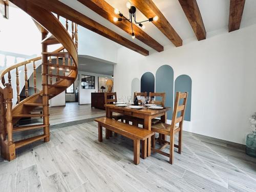 une salle à manger avec une table en bois et un escalier dans l'établissement La maison des vignes 3chambres jardin proche Reims, à Jonchery-sur-Vesle