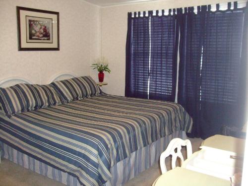 - une chambre avec un lit et une couverture rayée dans l'établissement Rainbow House, à Angel Fire