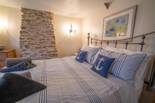 a bedroom with a bed with blue and white pillows at Number 60 Donkey Lane in Burton Bradstock