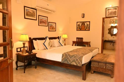 a bedroom with a bed with two tables and two lamps at The Shergarh in Khilchipur