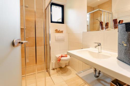 a bathroom with a sink and a toilet at Arlbergerhof Vital in Weissensee