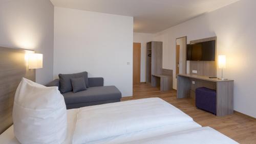 a hotel room with a bed and a couch at Bamberg Inn in Hallstadt