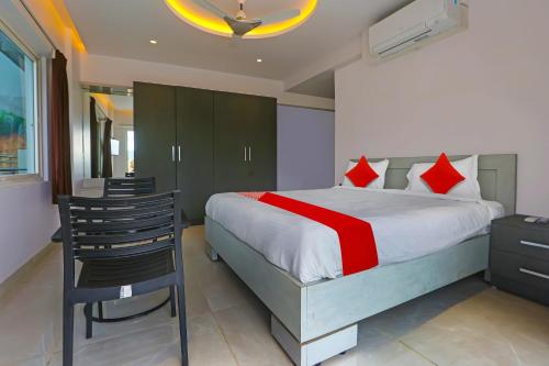 维沙卡帕特南Super Hotel O Botcha Convection的一间卧室，里面有一张床、一张桌子和一把椅子