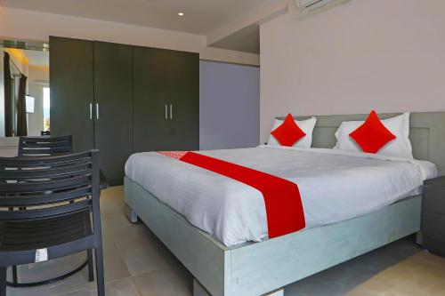 a bedroom with a large bed with red pillows at Super Hotel O Botcha Convection in Visakhapatnam