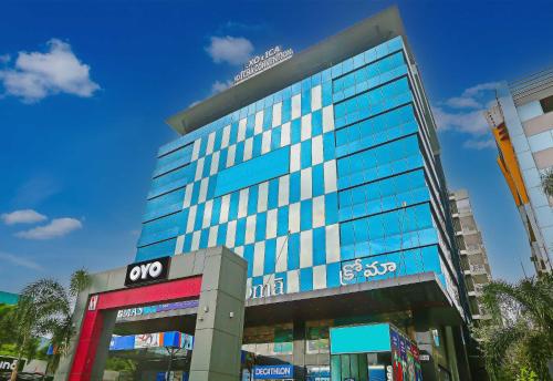 a tall building with glass windows in a city at Super Hotel O Botcha Convection in Visakhapatnam