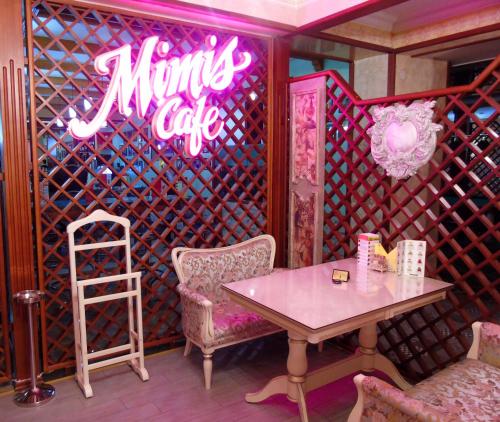 a dining room with a table and a neon sign at Amsterdam Hotel Aktobe in Aktobe