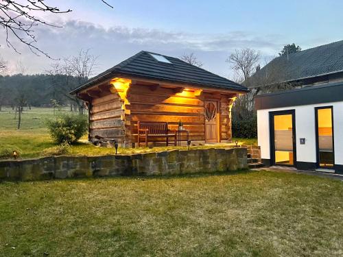 una cabaña de madera con un banco en un patio en Privat Sauna Whirlpool Blockhaus- Balance Apartments by M&A, en Witzenhausen