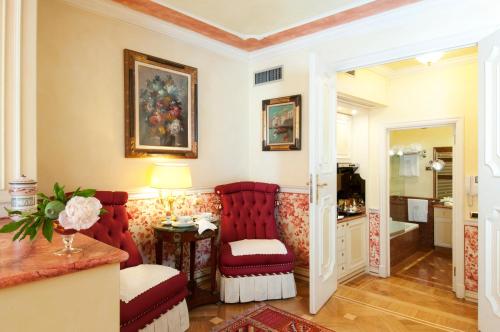 a room with two red chairs and a table at Petit Palais Hotel De Charme in Milan
