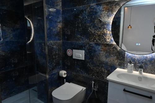 a bathroom with a toilet and a sink and a mirror at Vila La Familia in Ksamil