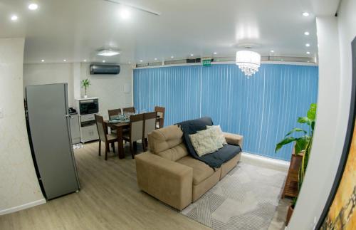 a living room with a couch and a dining room at Casa container in Tramandaí