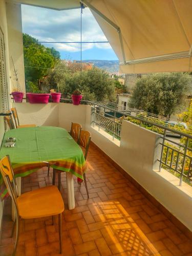 a dining room with a table and chairs and a balcony at Home4U, just 7km from airport in Markopoulo