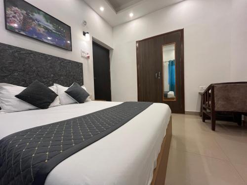 a bedroom with a large bed and a tv on the wall at Ashoka Hotel in Begusarai