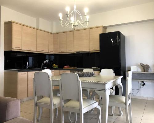 a kitchen with a table and chairs and a black refrigerator at KadroVilla II in Nafplio
