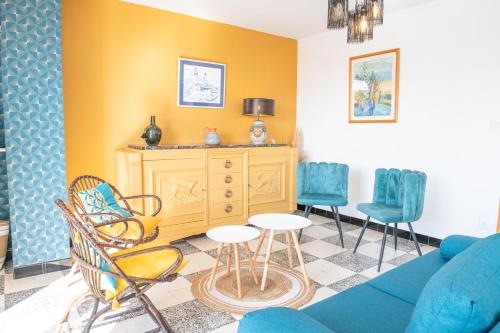 a living room with a blue couch and chairs at Les Terrasses 2 in Leucate-Plage