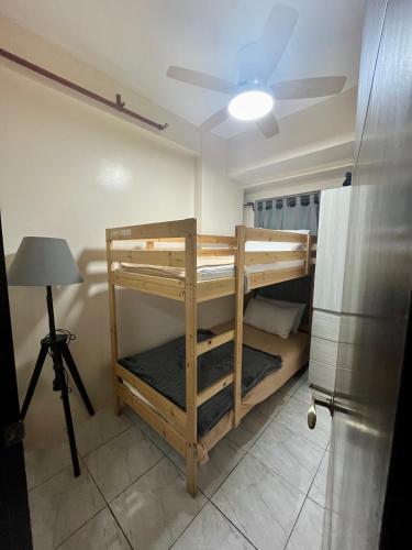 a room with a bunk bed and a ceiling fan at The Pine Lush Hideout in Baguio